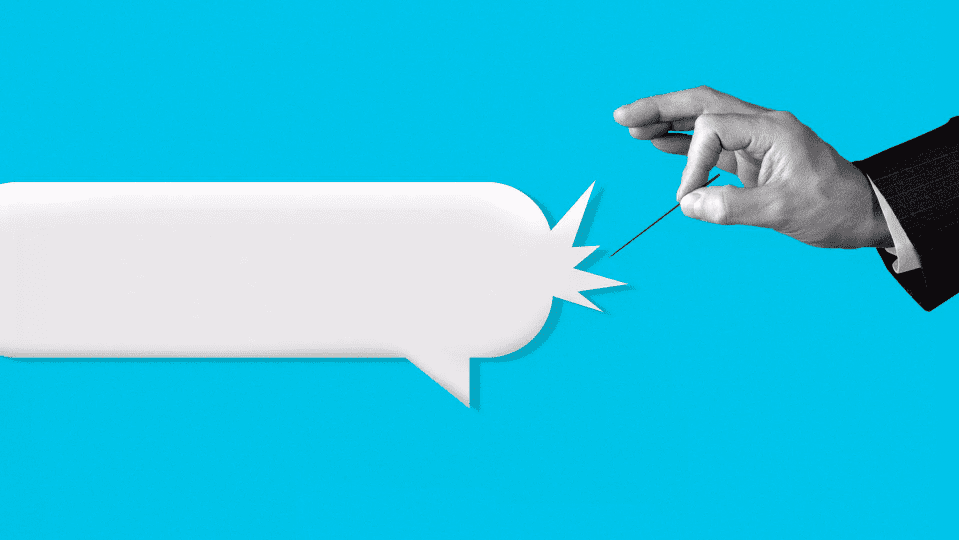 a man's hand popping a speech bubble with a needle