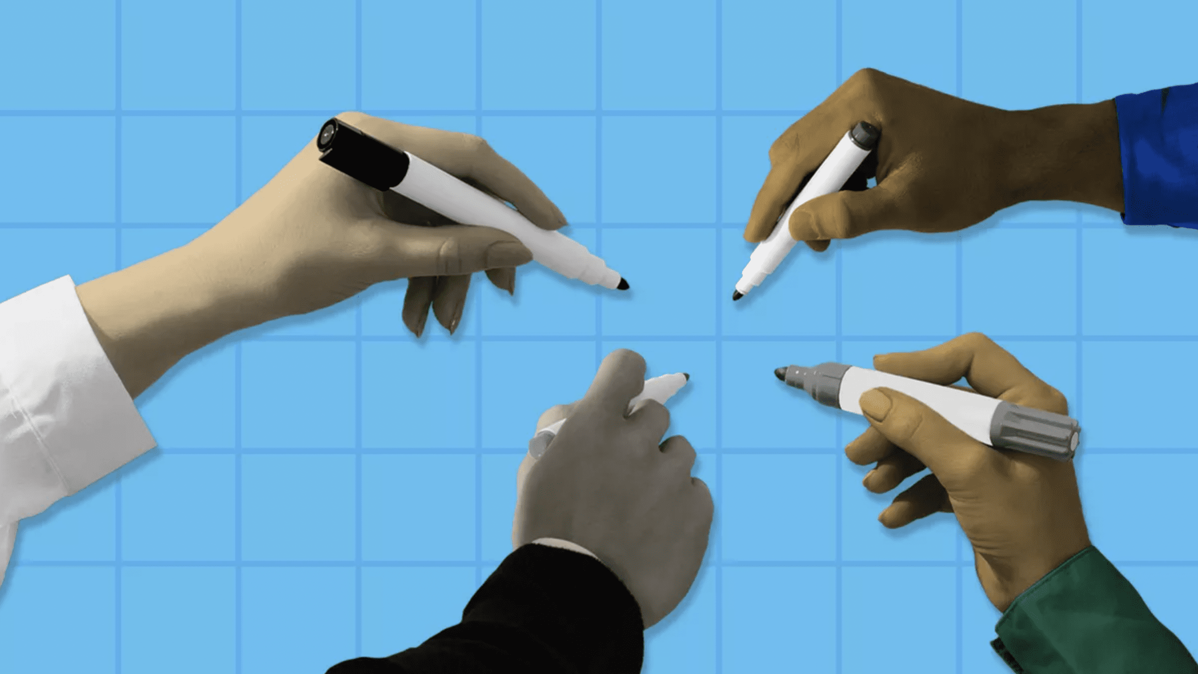 four hands holding markers, collaborating on a piece of graph paper