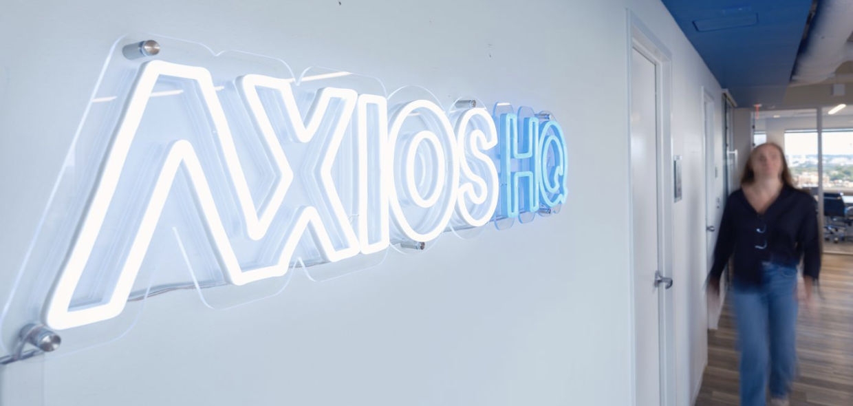 A lit Axios HQ sign